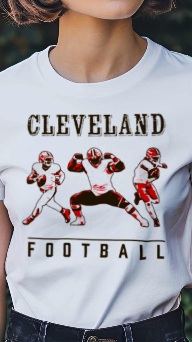 Person wearing a white t-shirt with 'Cleveland Football' graphic design outdoors.