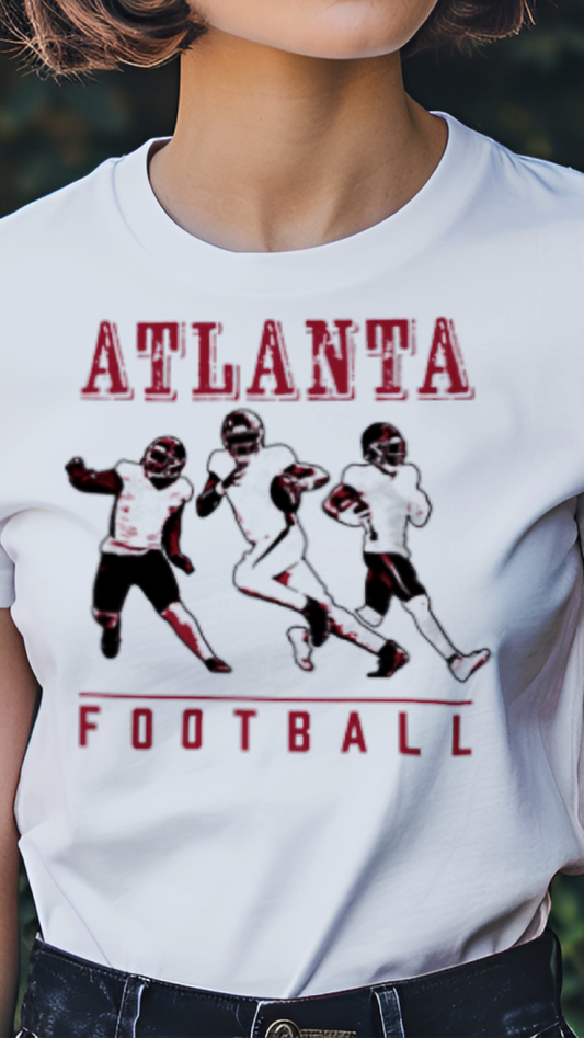 Person wearing a white t-shirt with 'Atlanta Football' graphic design outdoors.