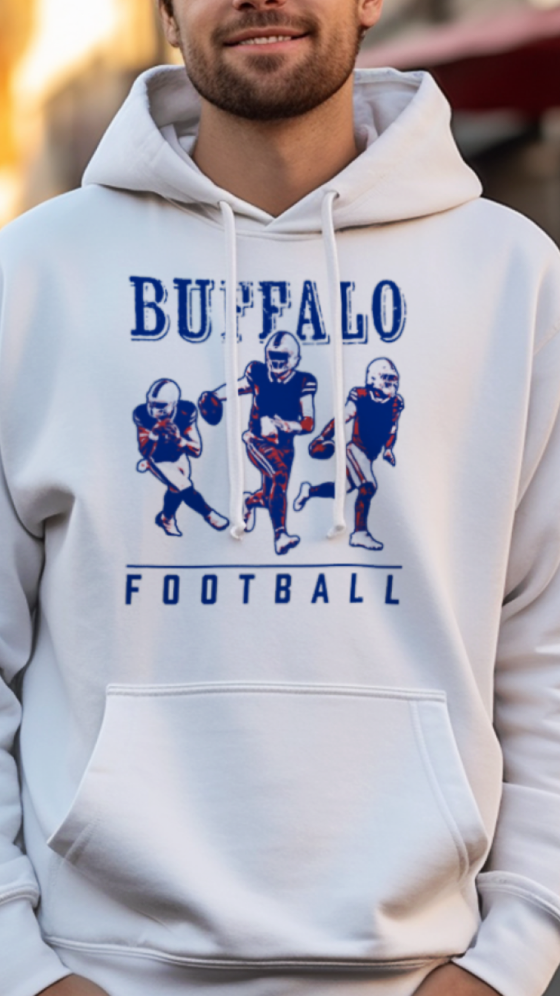 Man wearing a white hoodie with 'Buffalo Football' design on a street.