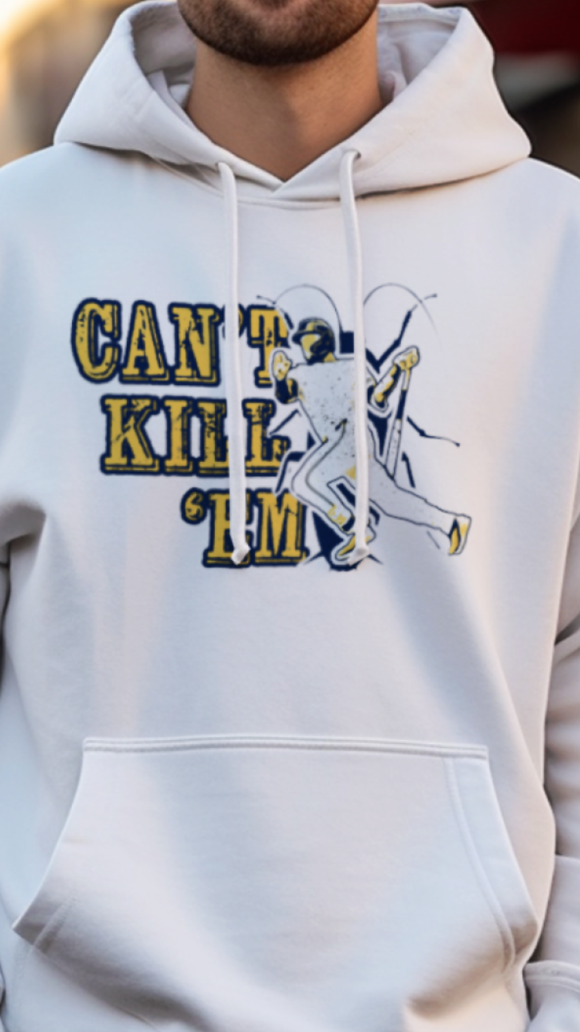 Person wearing a white hoodie with text and graphics on a street background