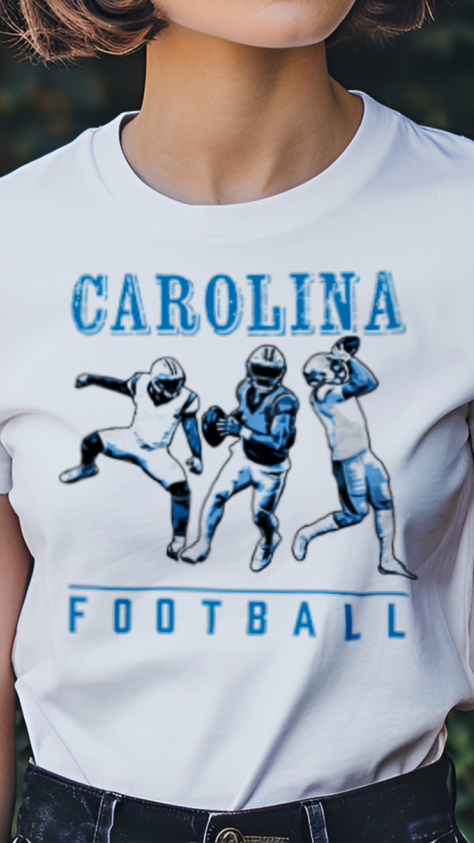 Person wearing a white t-shirt with 'Carolina Football' graphic design outdoors.