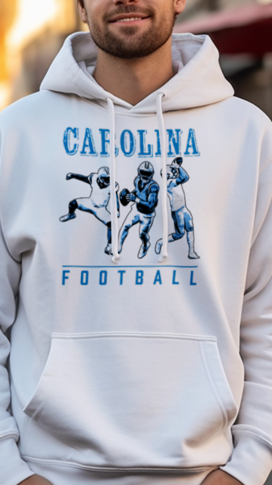 Man wearing a white hoodie with 'Carolina Football' design on a street background