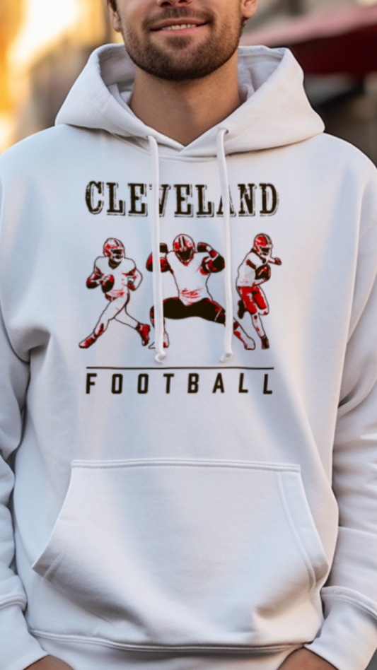 Man wearing a white hoodie with 'Cleveland Football' design on a street.