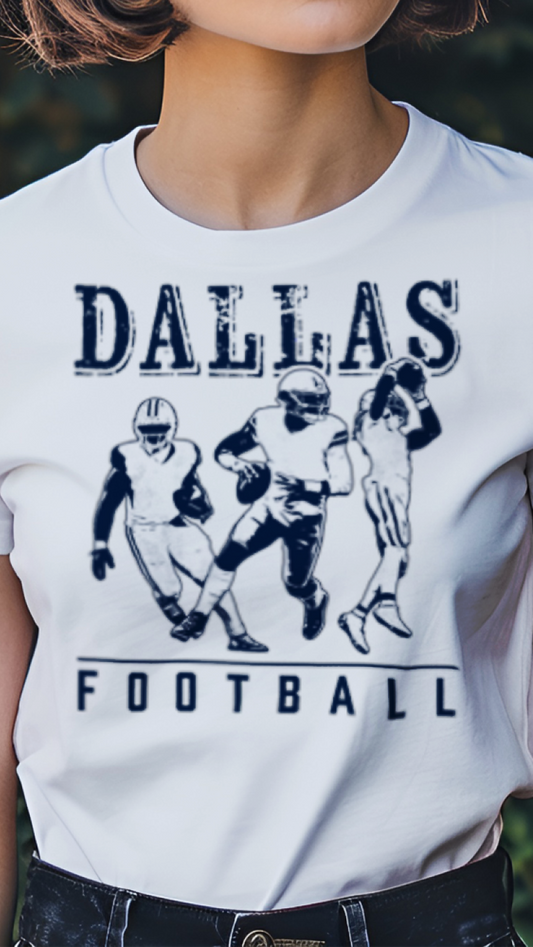Person wearing a white t-shirt with 'Dallas Football' design outdoors.