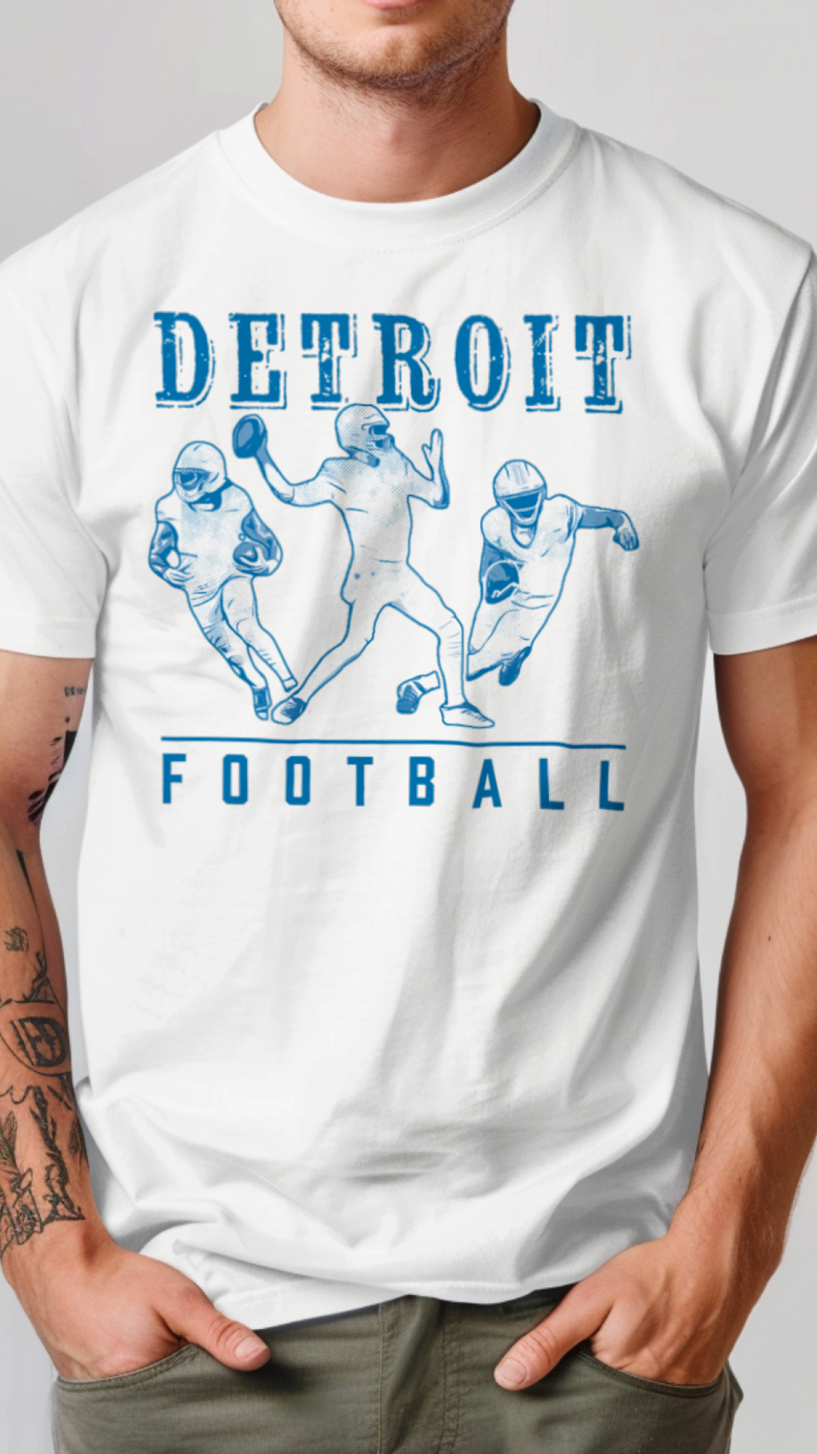 Person wearing a white t-shirt with 'Detroit Football' design on a plain background