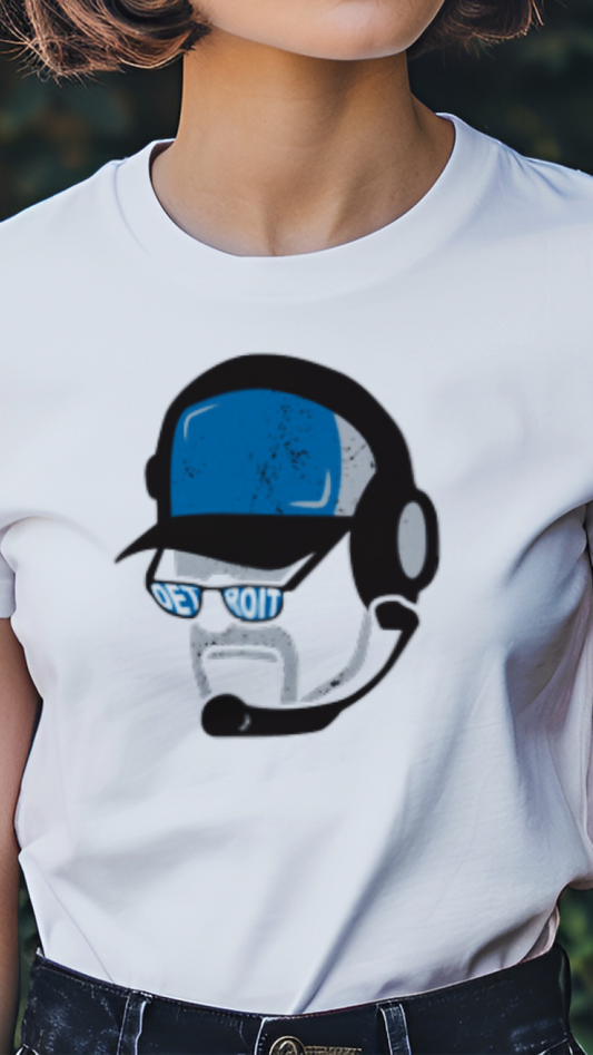 Person wearing a white t-shirt with a graphic design of a robot wearing headphones, standing in a garden.