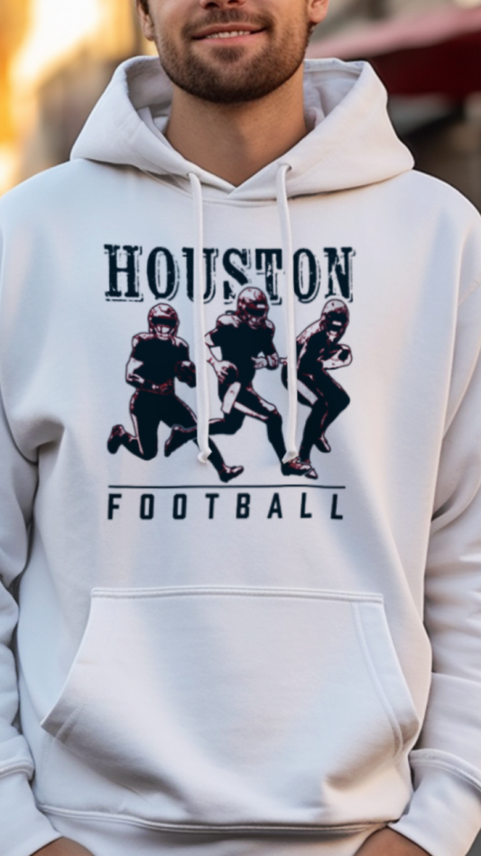 Person wearing a white hoodie with 'Houston Football' text and graphics on a city street.