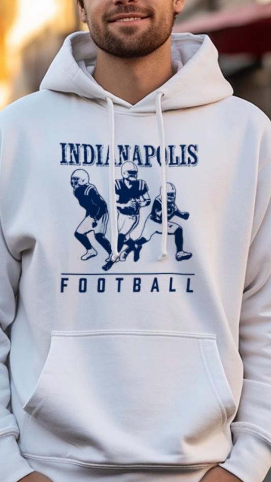 Man wearing a white hoodie with 'Indianapolis Football' design on a street background