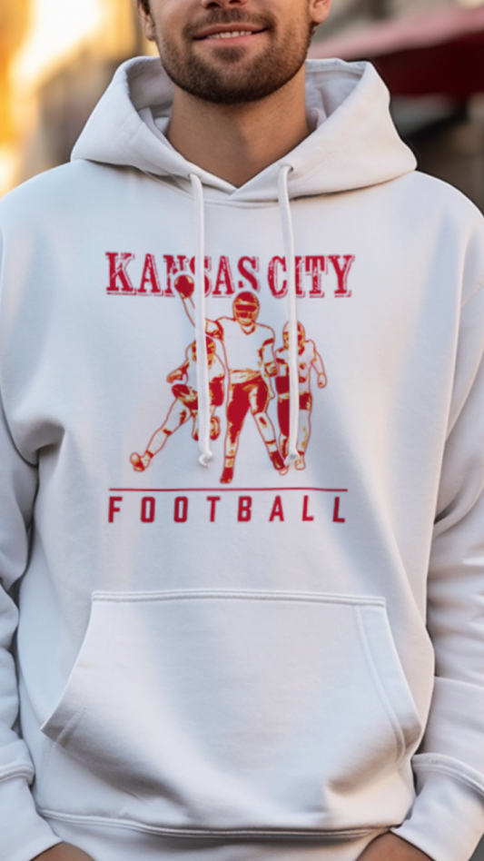 Man wearing a white hoodie with 'Kansas City Football' design on a street.