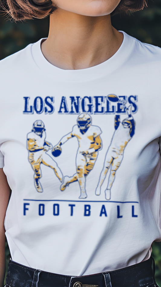 Person wearing a white t-shirt with 'Los Angeles Football' design in a garden setting