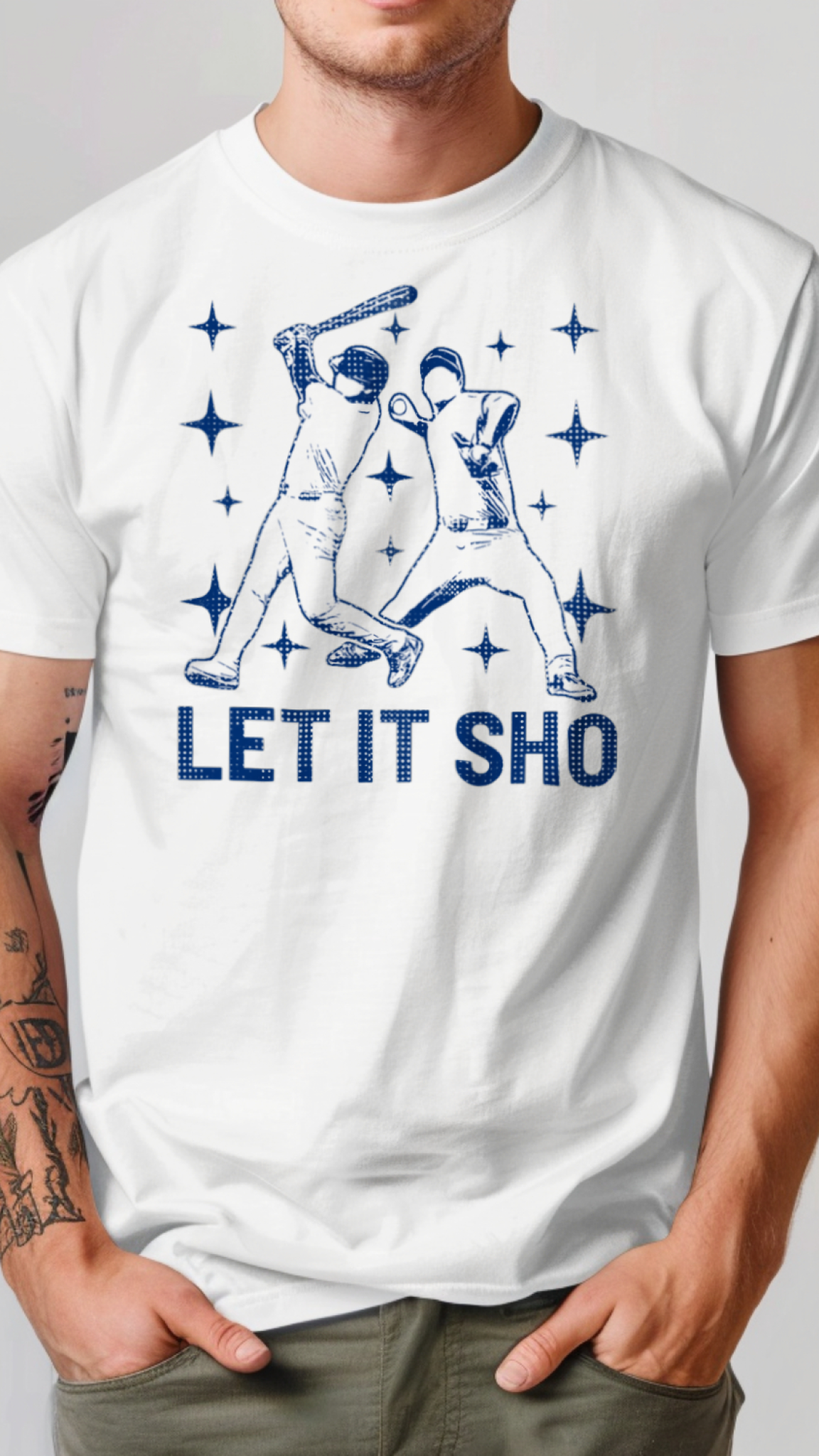 White t-shirt with blue graphic and 'LET IT SHO' text worn by a person on a plain background