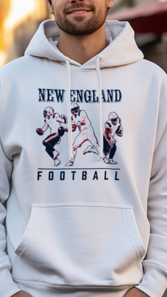 Man wearing a white hoodie with 'New England Football' design on a street.