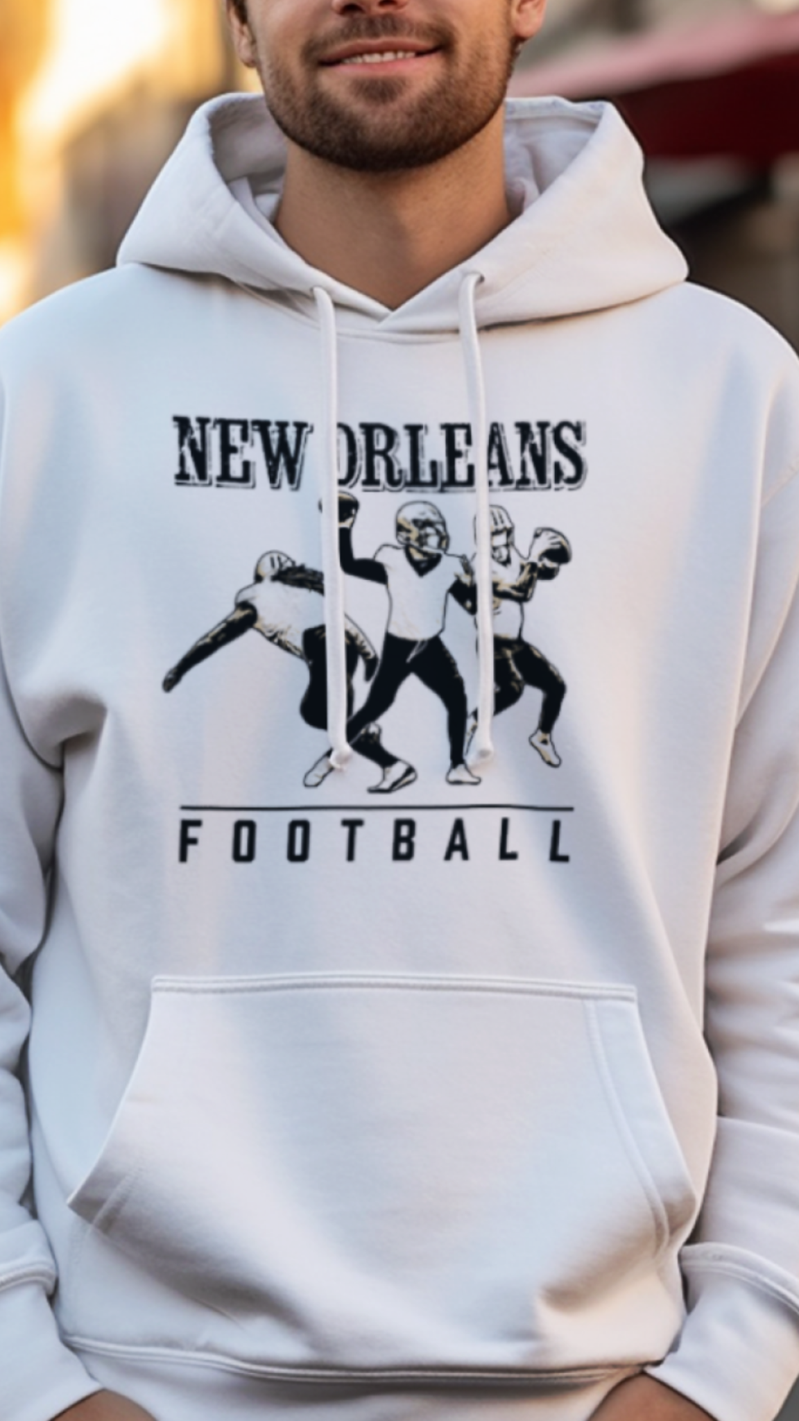 Person wearing a white hoodie with 'New Orleans Football' text and graphics on a street background
