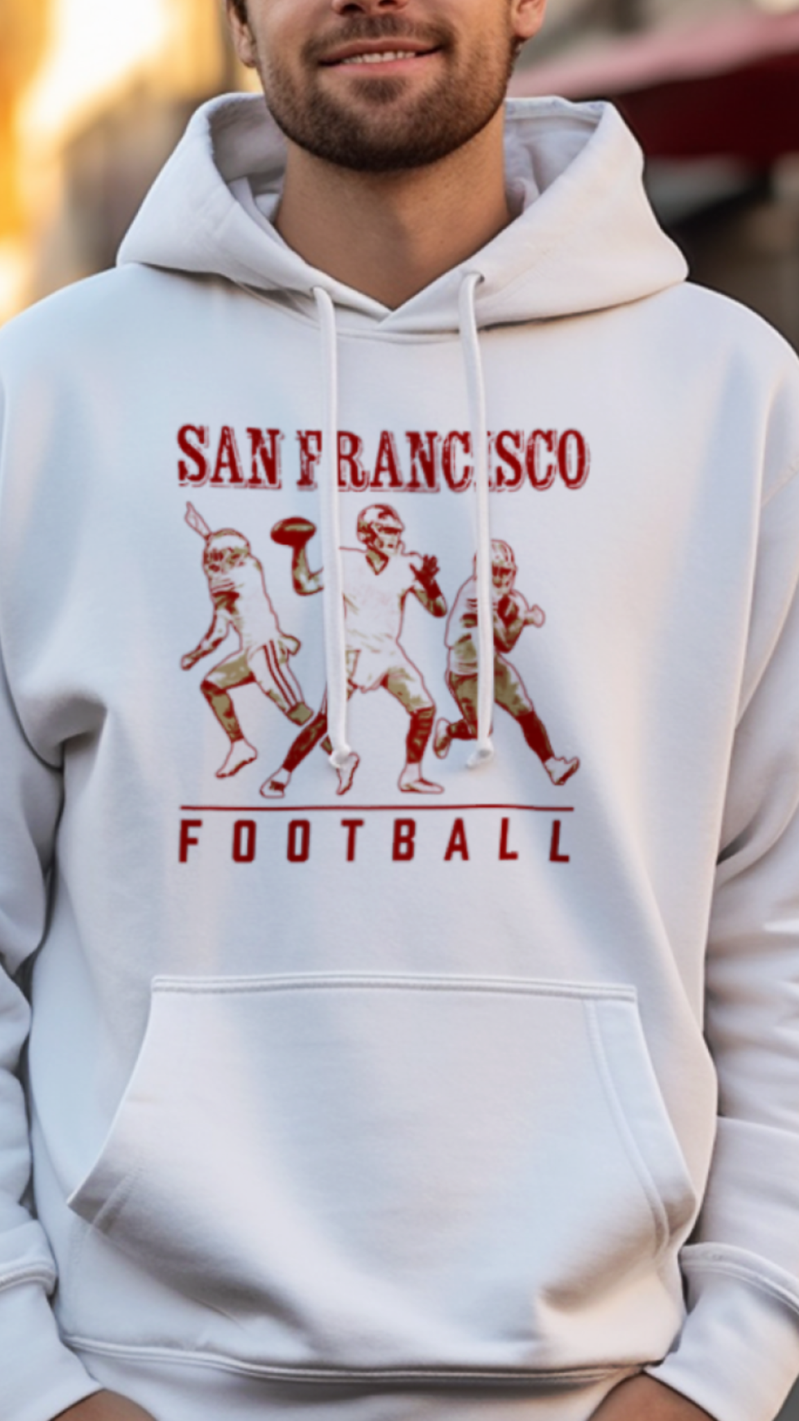 Man wearing a white hoodie with 'San Francisco Football' design on a street.