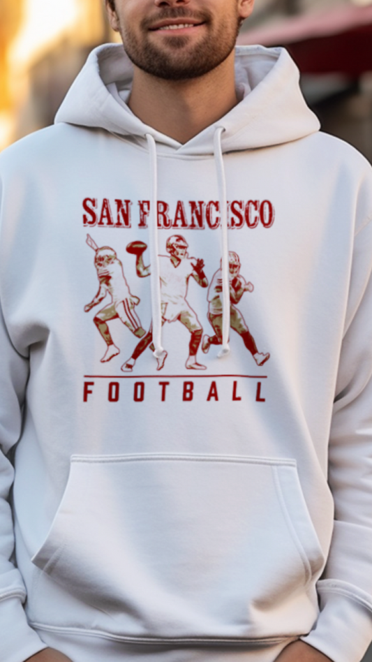 Man wearing a white hoodie with 'San Francisco Football' design on a street.