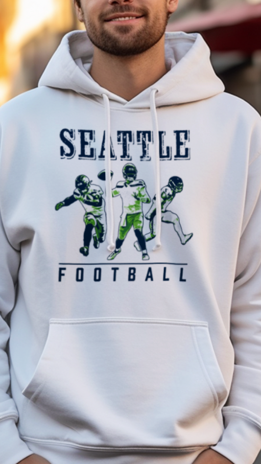 Person wearing a white hoodie with 'Seattle Football' text and graphics on a street background